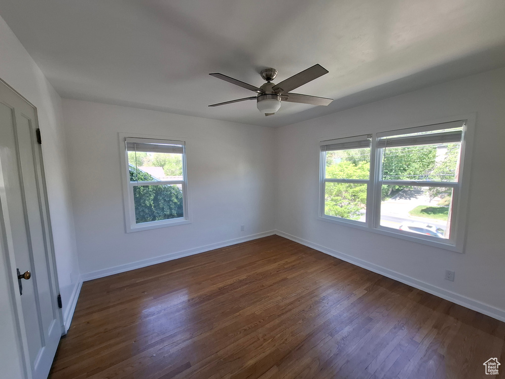 Spare room featuring dark wood finished floors and ceiling fan