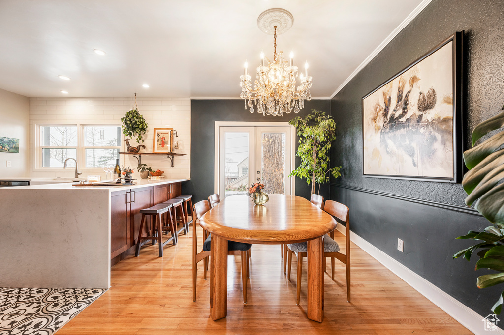 Dining space with light wood-style flooring, a chandelier, crown molding, and recessed lighting
