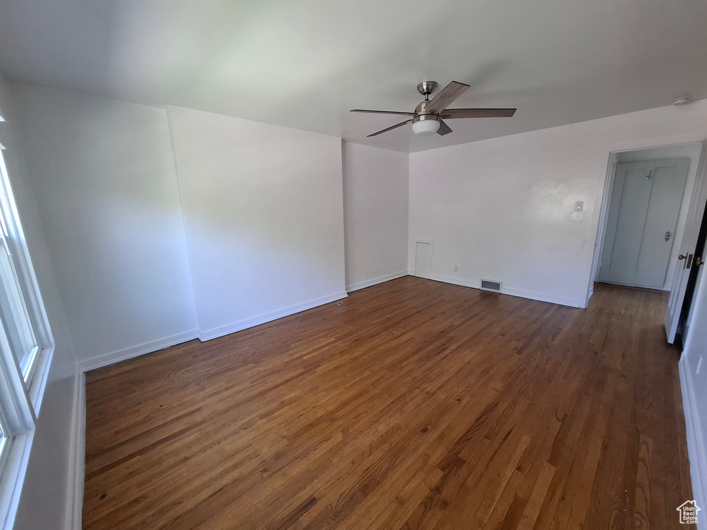 Empty room with dark wood finished floors and ceiling fan