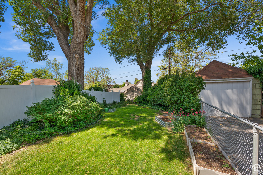 View of yard with a vegetable garden and an outbuilding