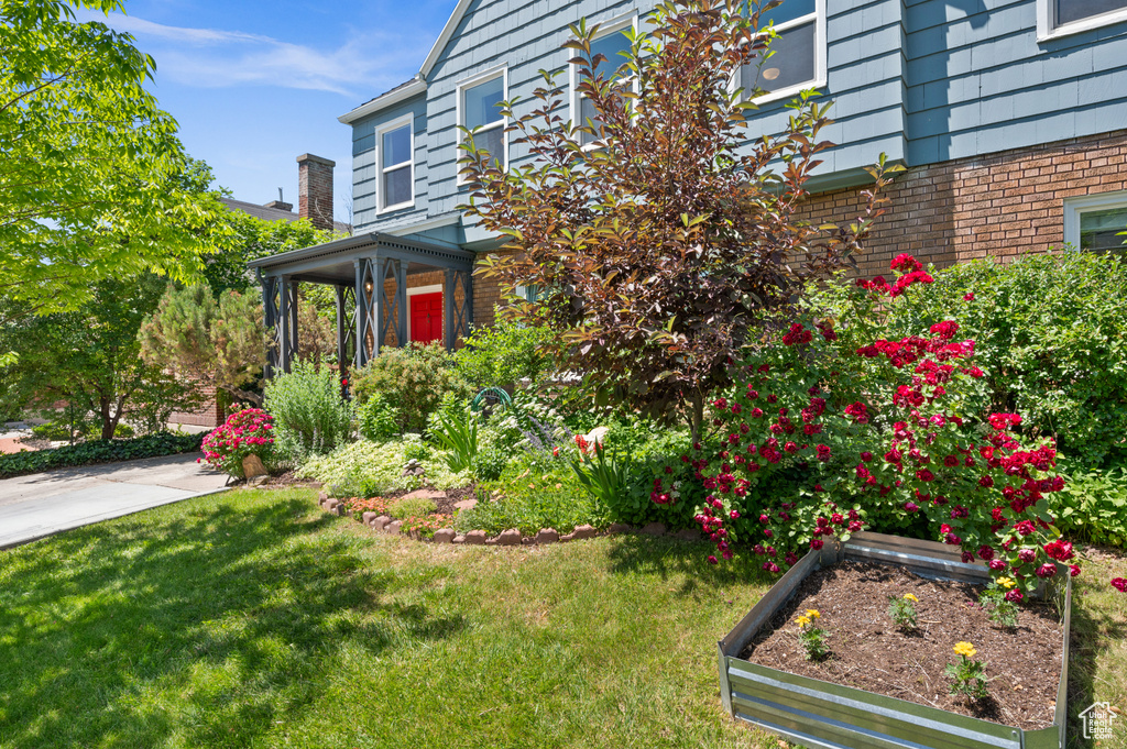 View of home\\\\\\\\\\\\\\\'s exterior featuring a lawn, brick siding, and a garden