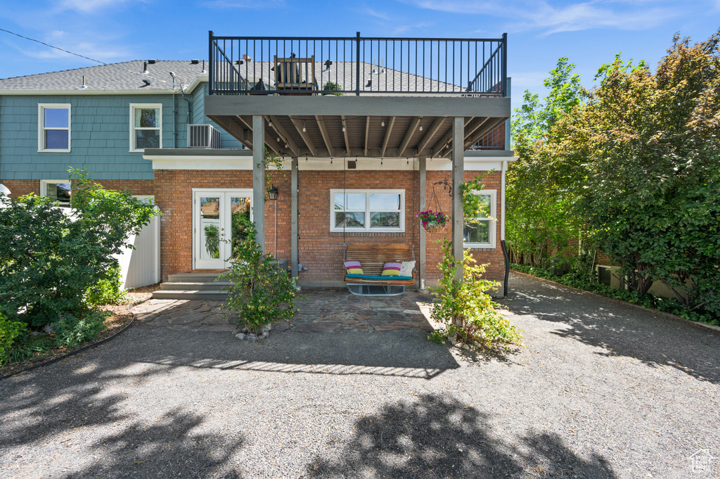 Rear view of property featuring brick siding and a balcony
