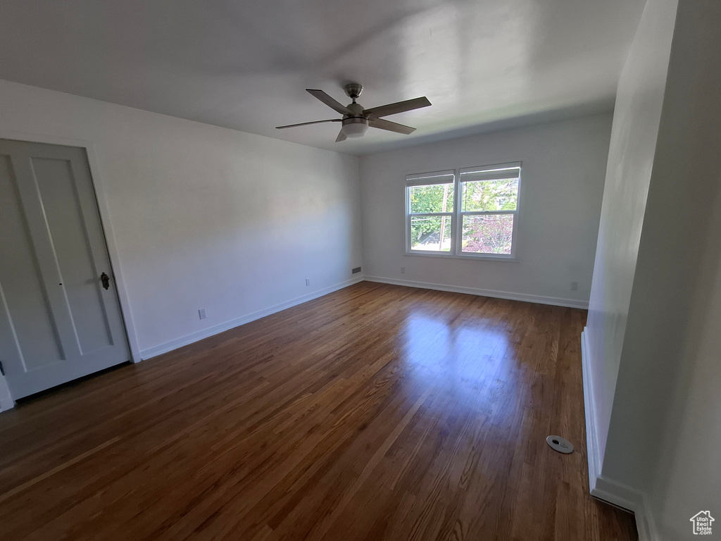 Spare room featuring ceiling fan and dark wood-type flooring
