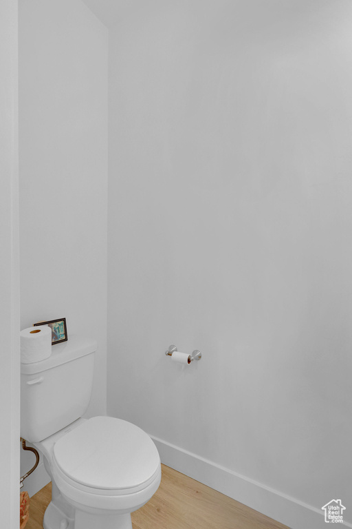 Bathroom with baseboards, toilet, and wood finished floors