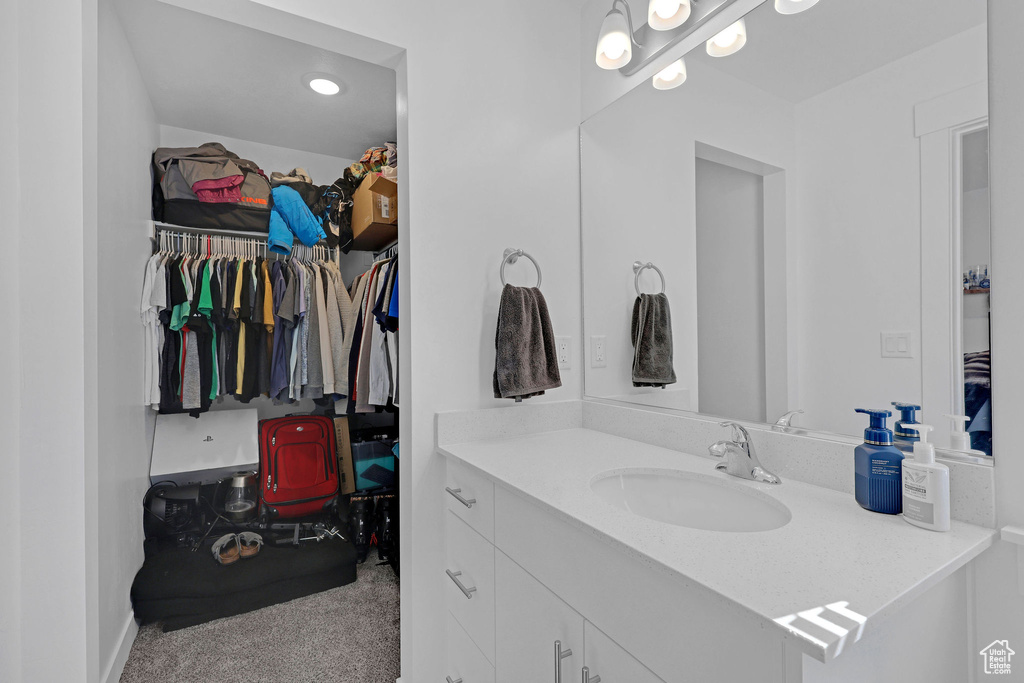 Bathroom featuring vanity and a walk in closet