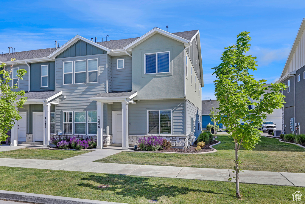 View of front facade featuring a front yard and board and batten siding