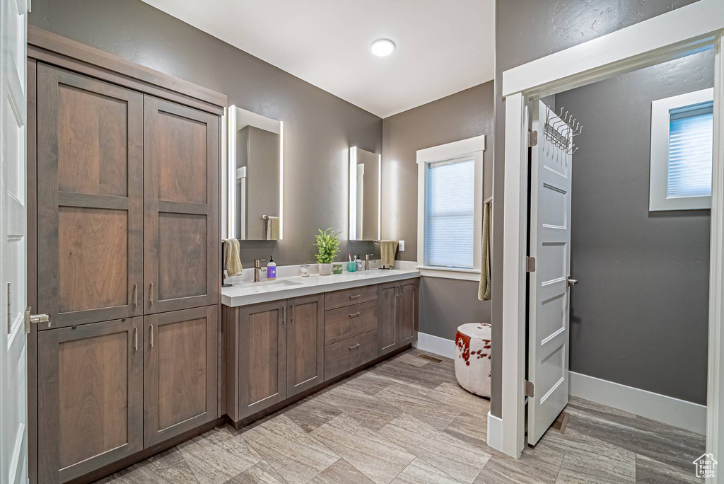 Full bathroom with double vanity and baseboards