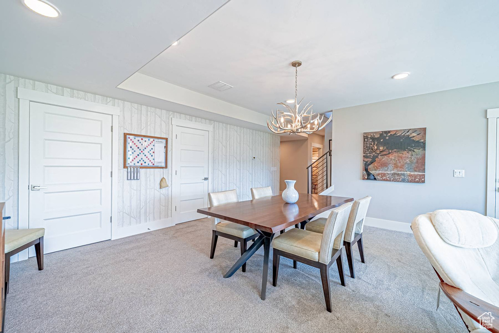 Dining area with light colored carpet, a chandelier, baseboards, and recessed lighting
