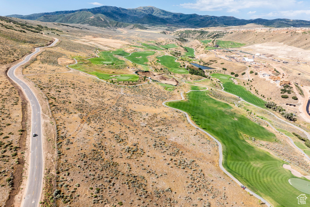 Aerial view of property's location featuring a mountainous background and a golf club