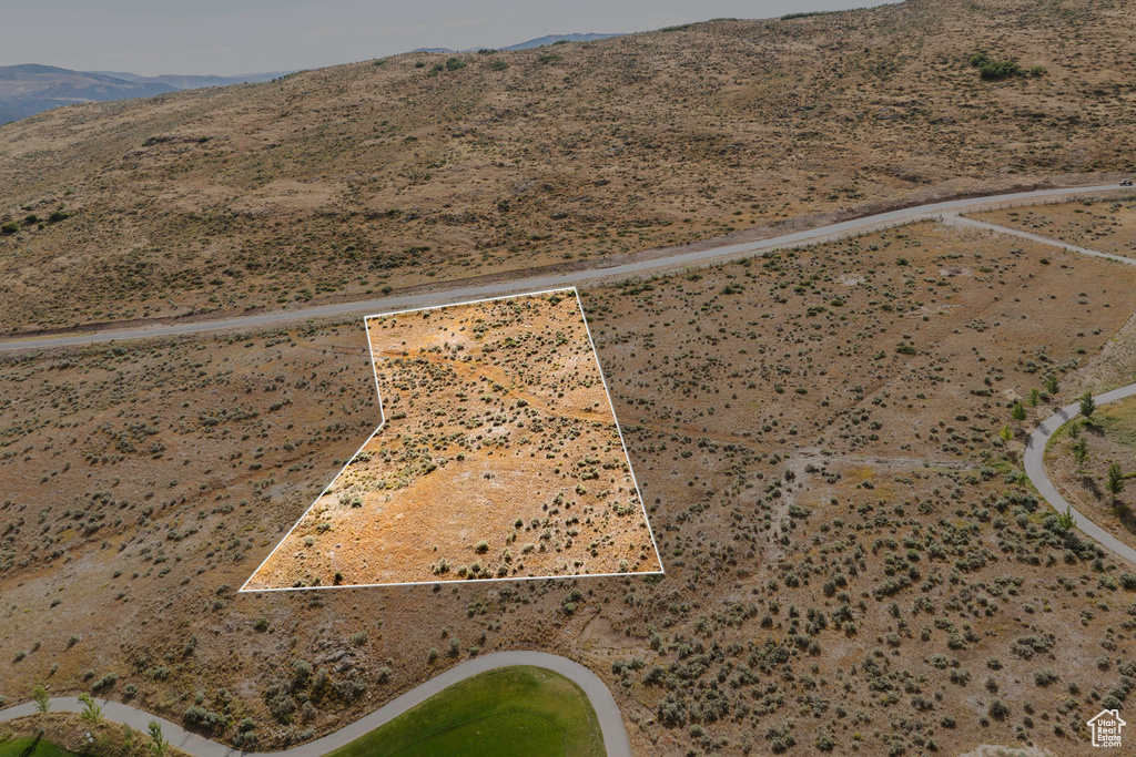 Aerial view of property's location with property parcel outlined, a mountainous background, and a desert landscape