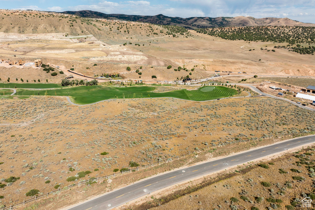Aerial view of property and surrounding area with mountains and a golf club