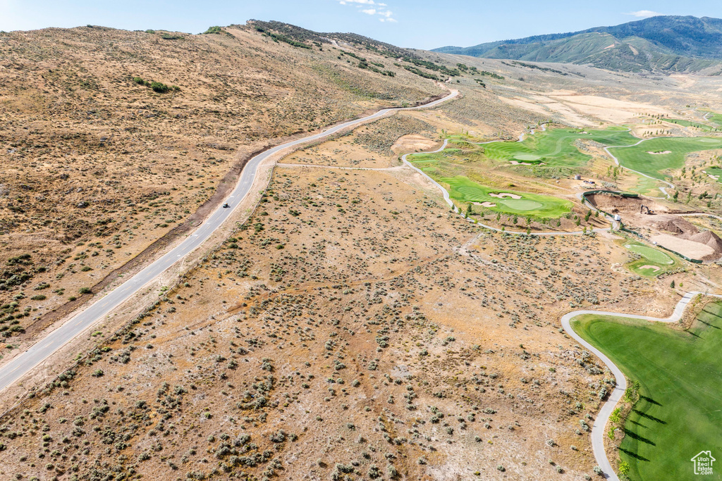 Aerial view of property's location featuring a mountainous background and a golf course