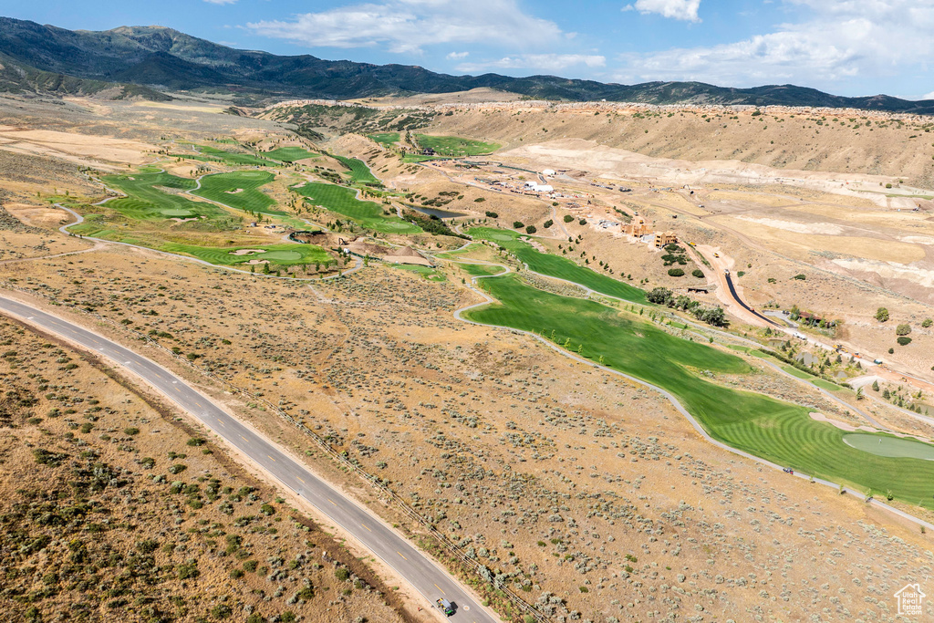 Aerial overview of property's location with a mountainous background and a golf course