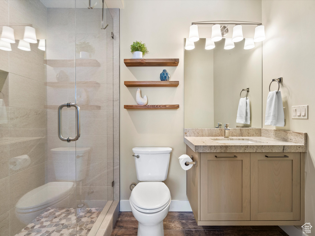 Full bath featuring toilet, vanity, and a stall shower