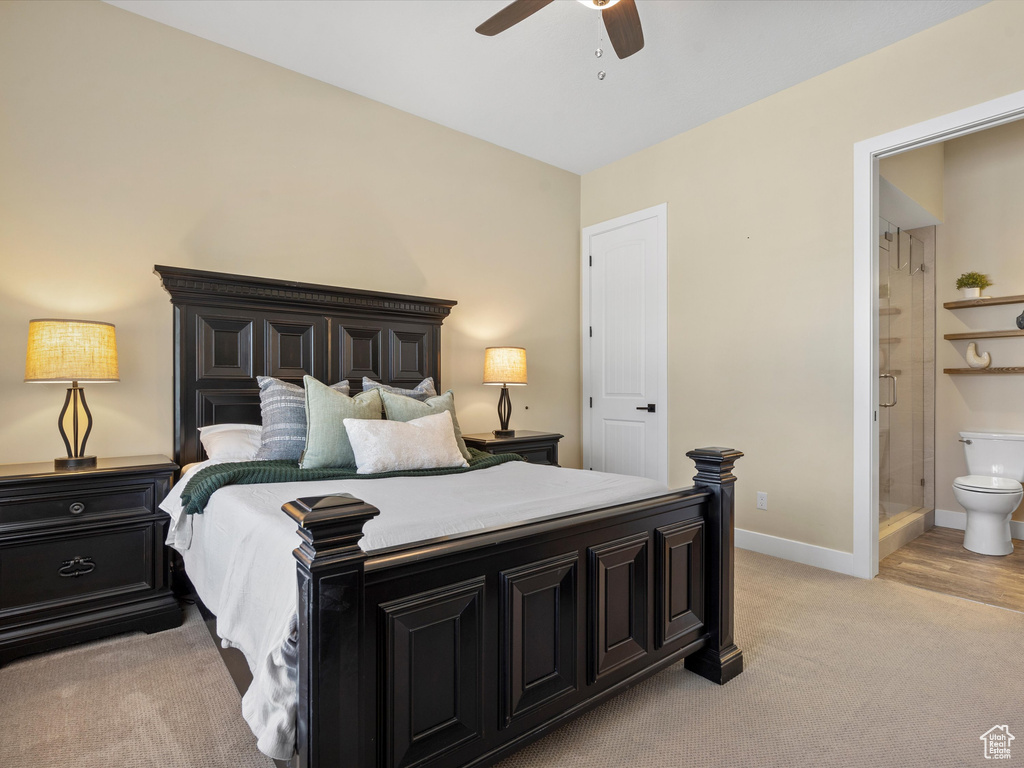 Bedroom featuring light colored carpet, baseboards, connected bathroom, and ceiling fan