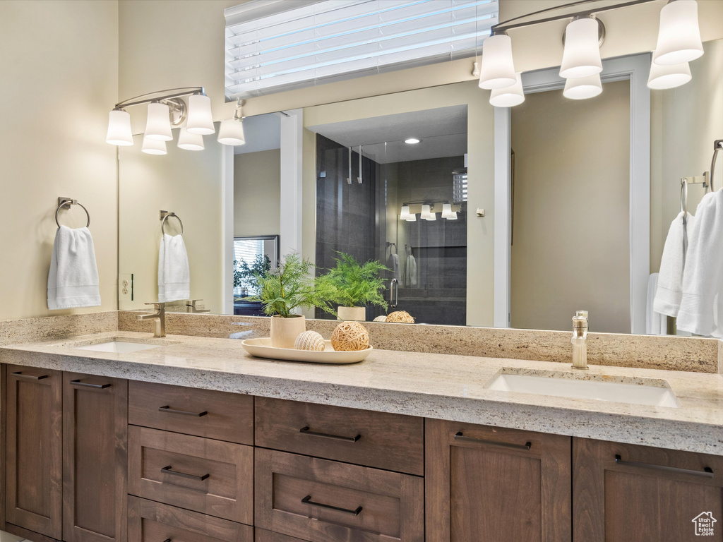 Full bath featuring double vanity, a shower stall, and plenty of natural light