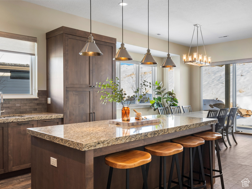 Kitchen with a sink, plenty of natural light, a center island, and backsplash