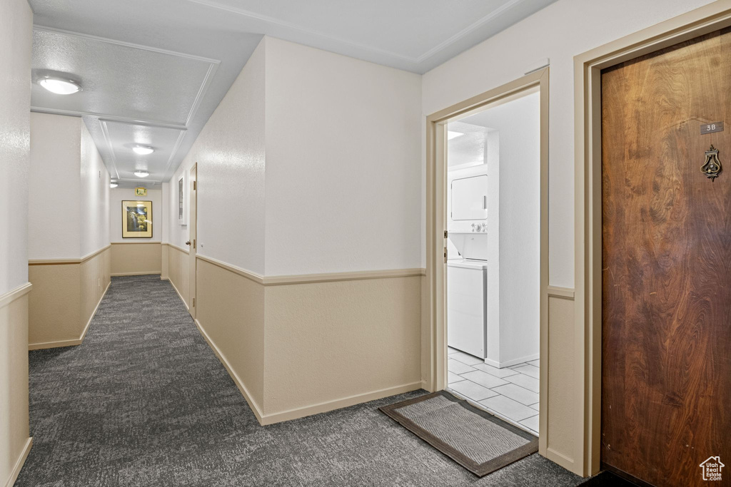 Hallway with estacked washer and dryer and carpet