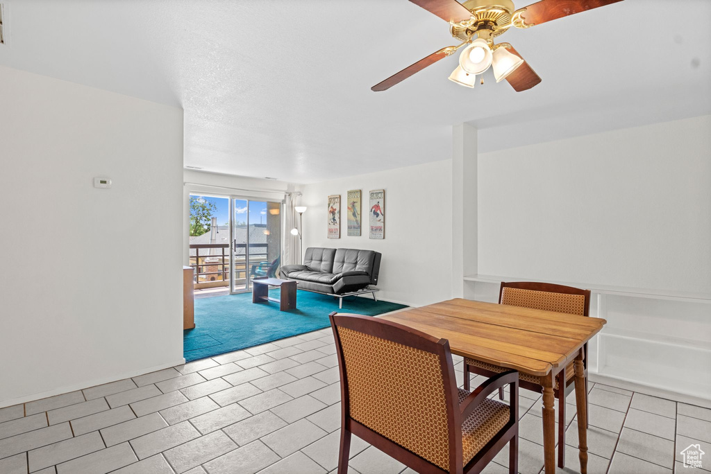 Dining space with ceiling fan and light tile patterned flooring