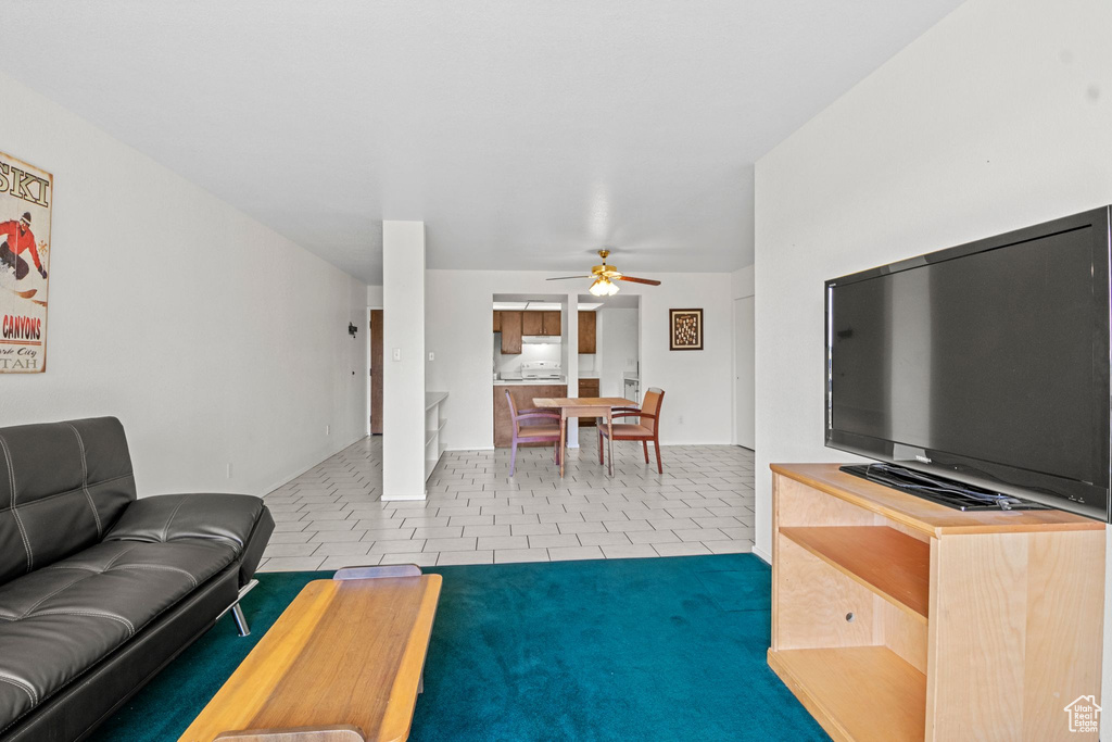 Living area featuring a ceiling fan and tile patterned floors