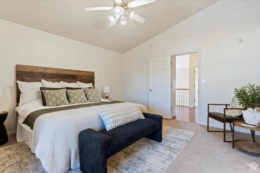 Carpeted bedroom with ceiling fan and high vaulted ceiling