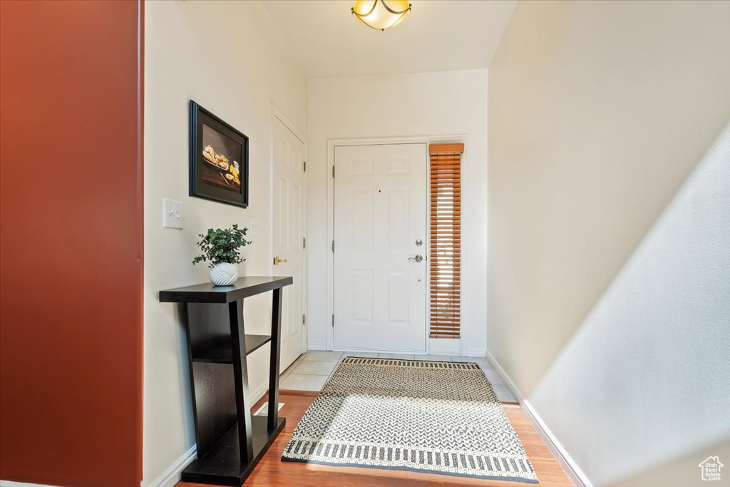 Entryway with light wood finished floors and baseboards