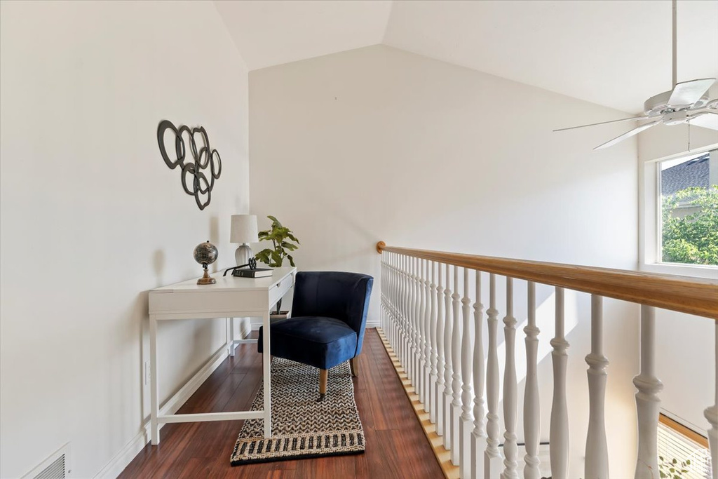 Home office with lofted ceiling, baseboards, ceiling fan, and wood finished floors