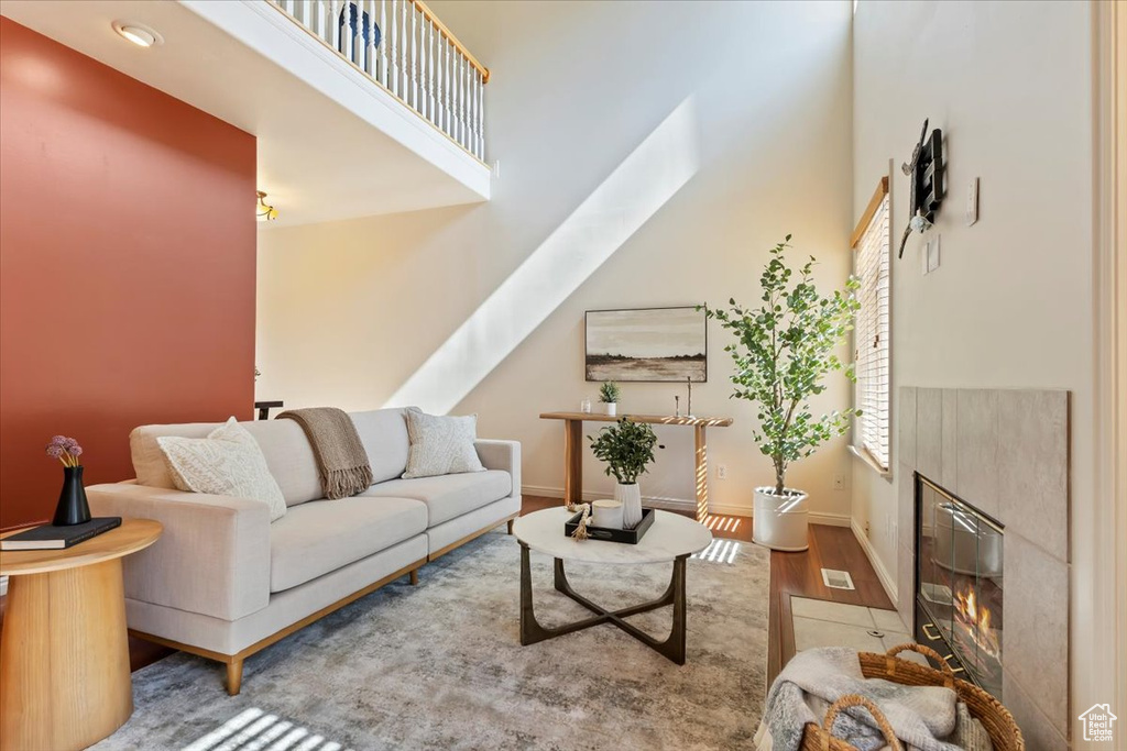 Living area featuring wood finished floors, a fireplace with flush hearth, and baseboards