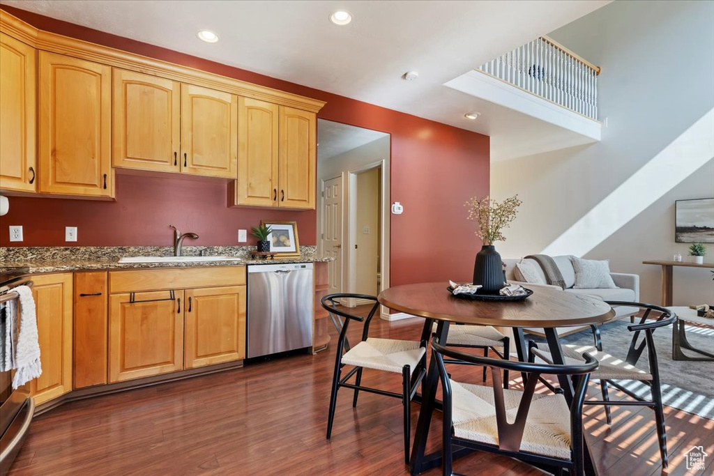Kitchen with stainless steel dishwasher, a sink, dark wood finished floors, recessed lighting, and stone countertops