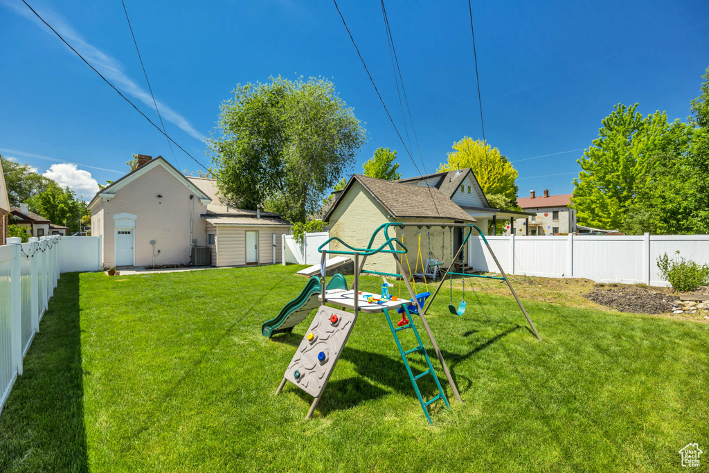 View of yard with a playground and central air condition unit