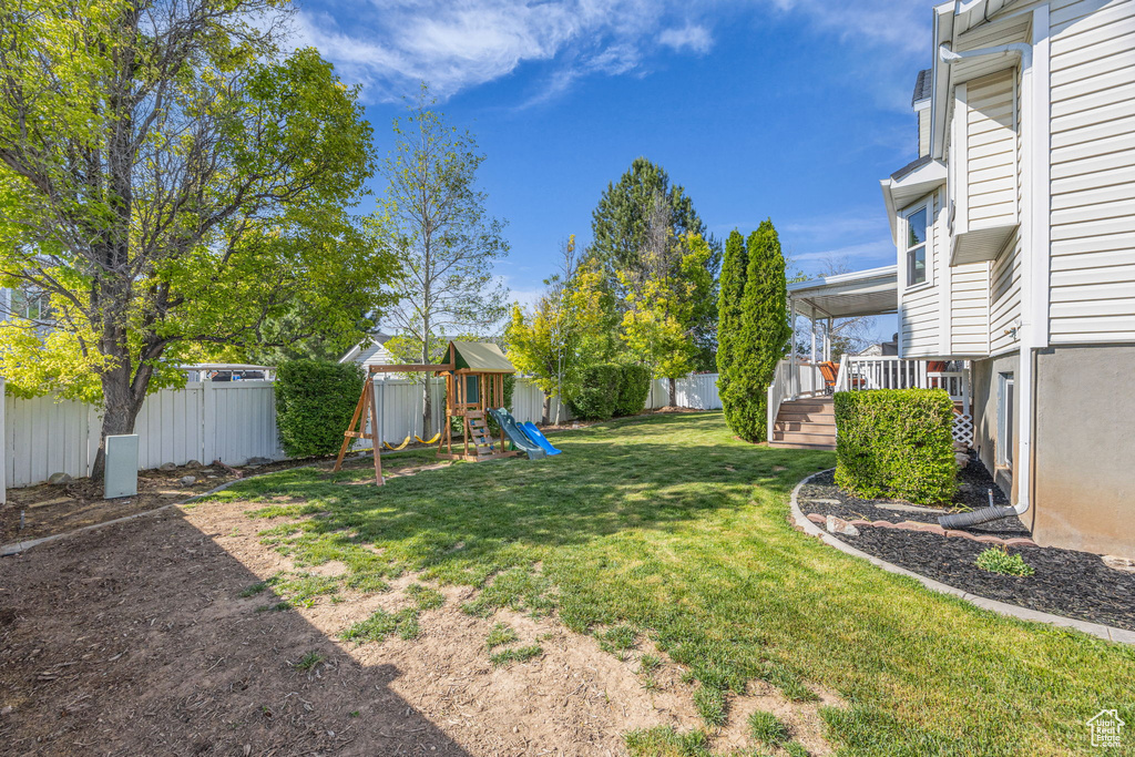 View of yard featuring a playground and a deck