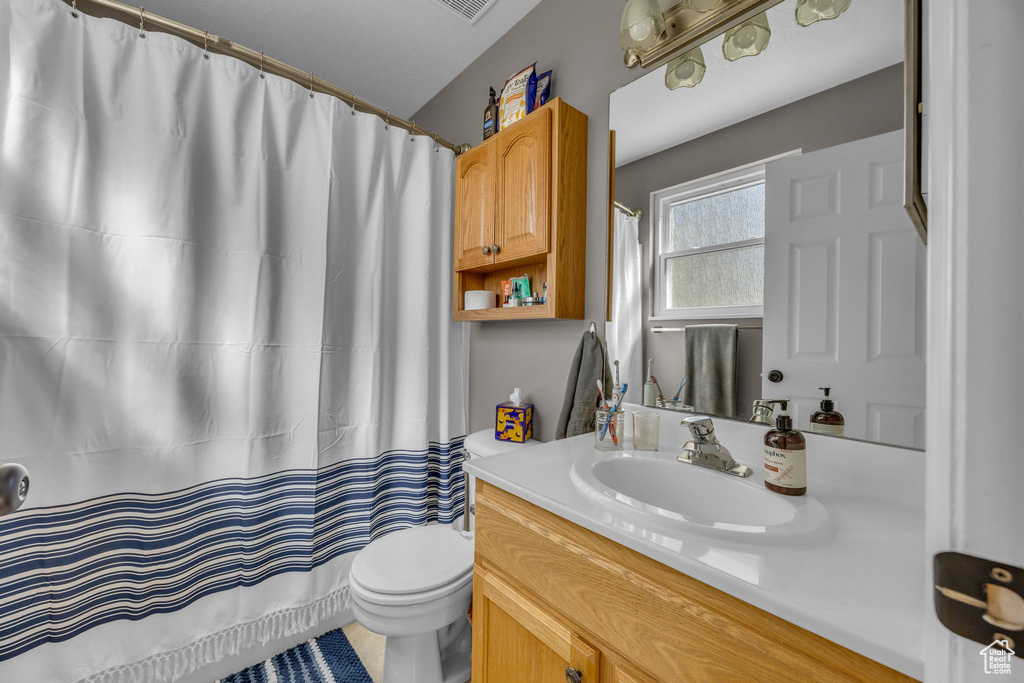 Full bathroom with vanity, toilet, and a shower with curtain