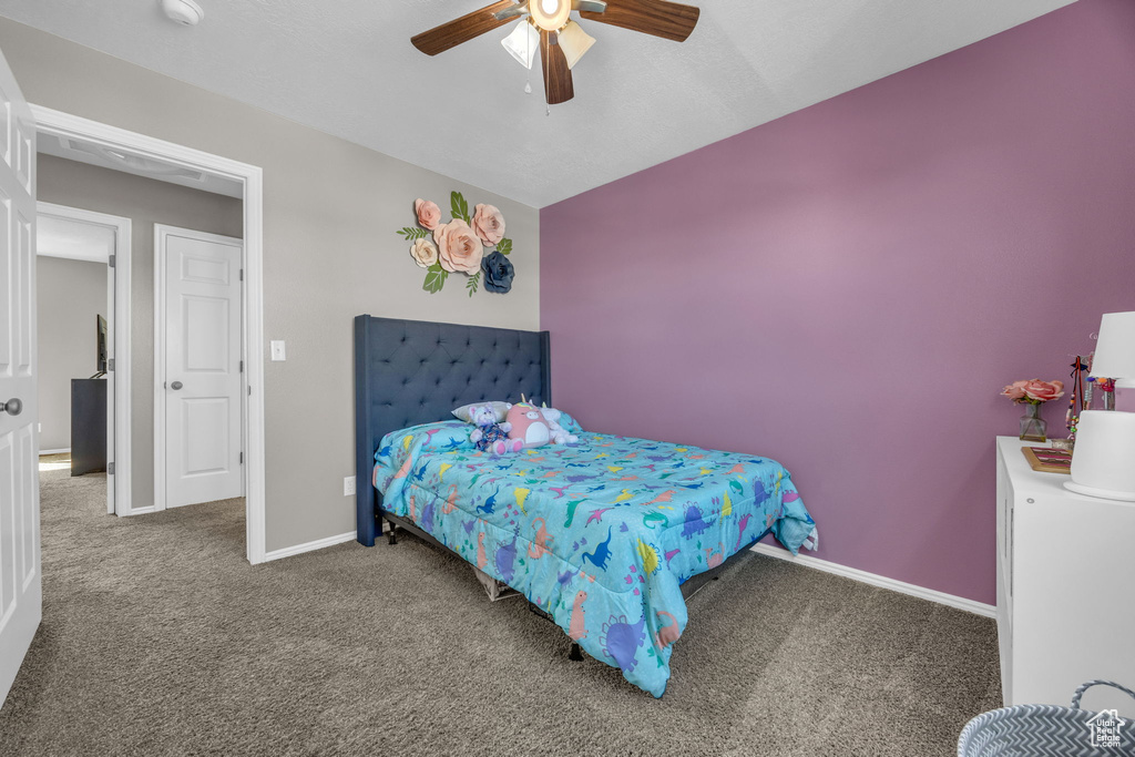Carpeted bedroom featuring baseboards and a ceiling fan