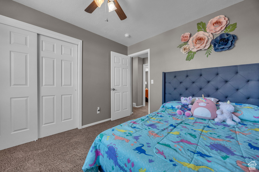 Bedroom featuring carpet floors, ceiling fan, baseboards, and a closet