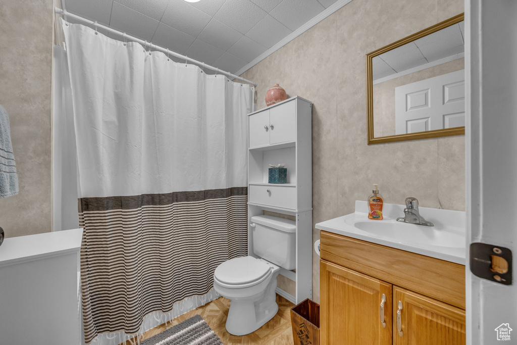 Bathroom with vanity, toilet, crown molding, and curtained shower