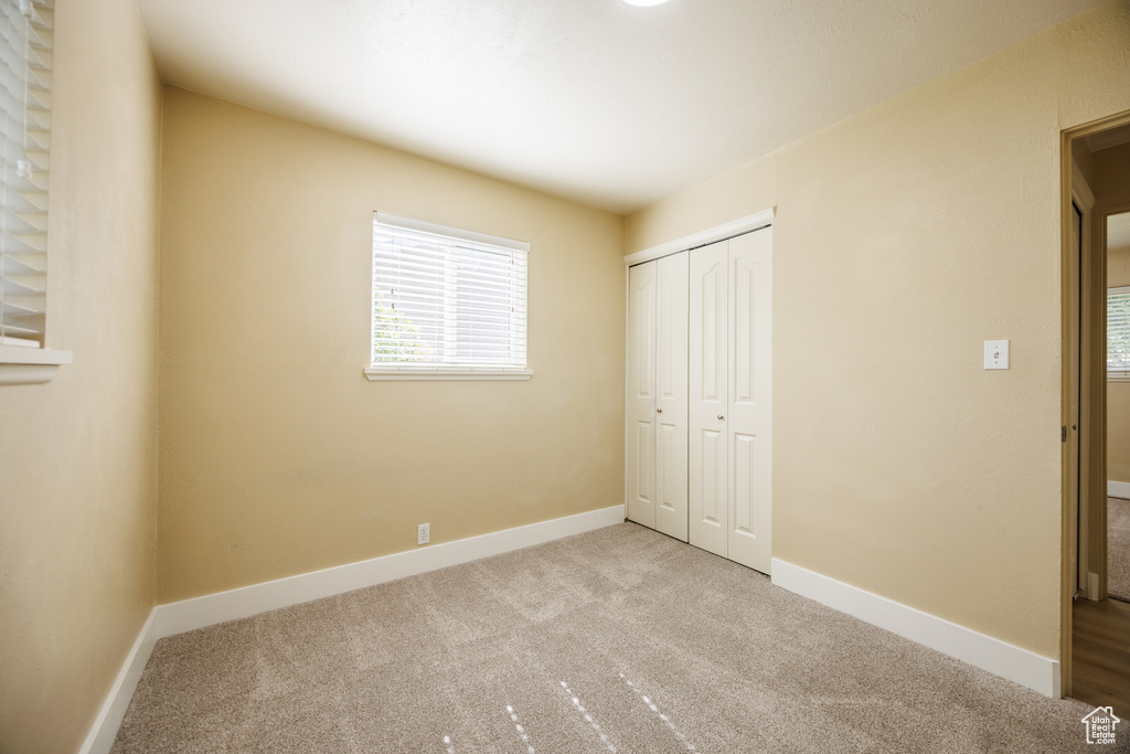 Unfurnished bedroom featuring carpet, a closet, and baseboards