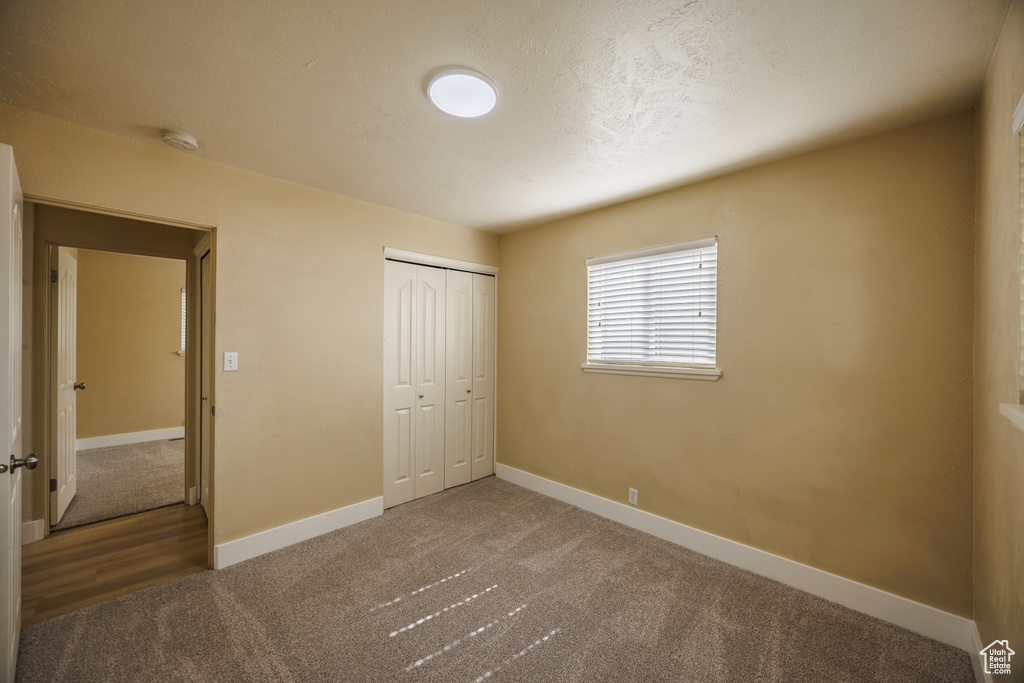 Unfurnished bedroom with carpet flooring, baseboards, and a closet
