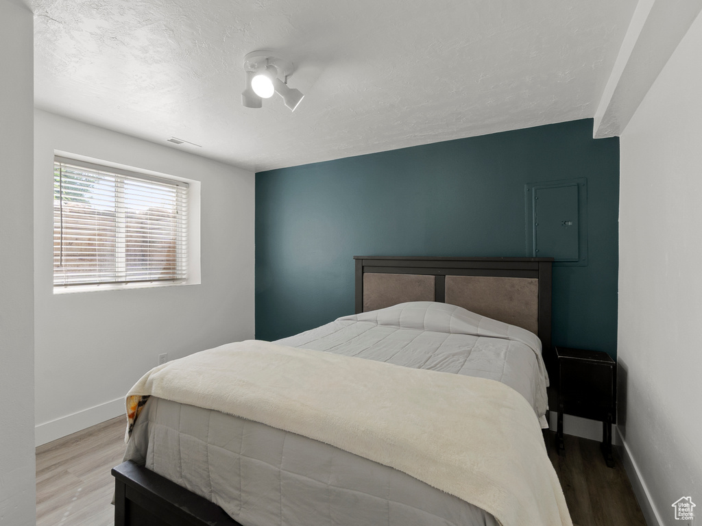 Bedroom with wood finished floors, baseboards, and a ceiling fan