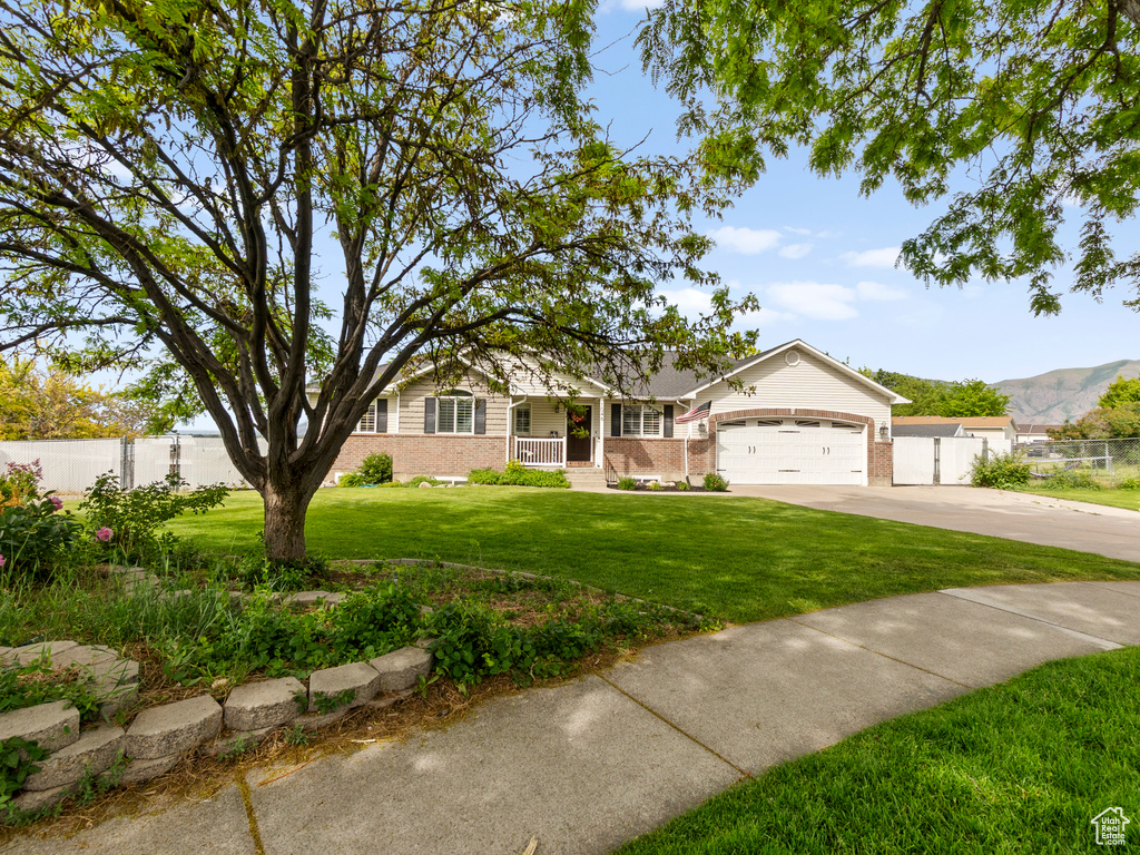 Ranch-style house featuring brick siding, concrete driveway, an attached garage, and covered porch