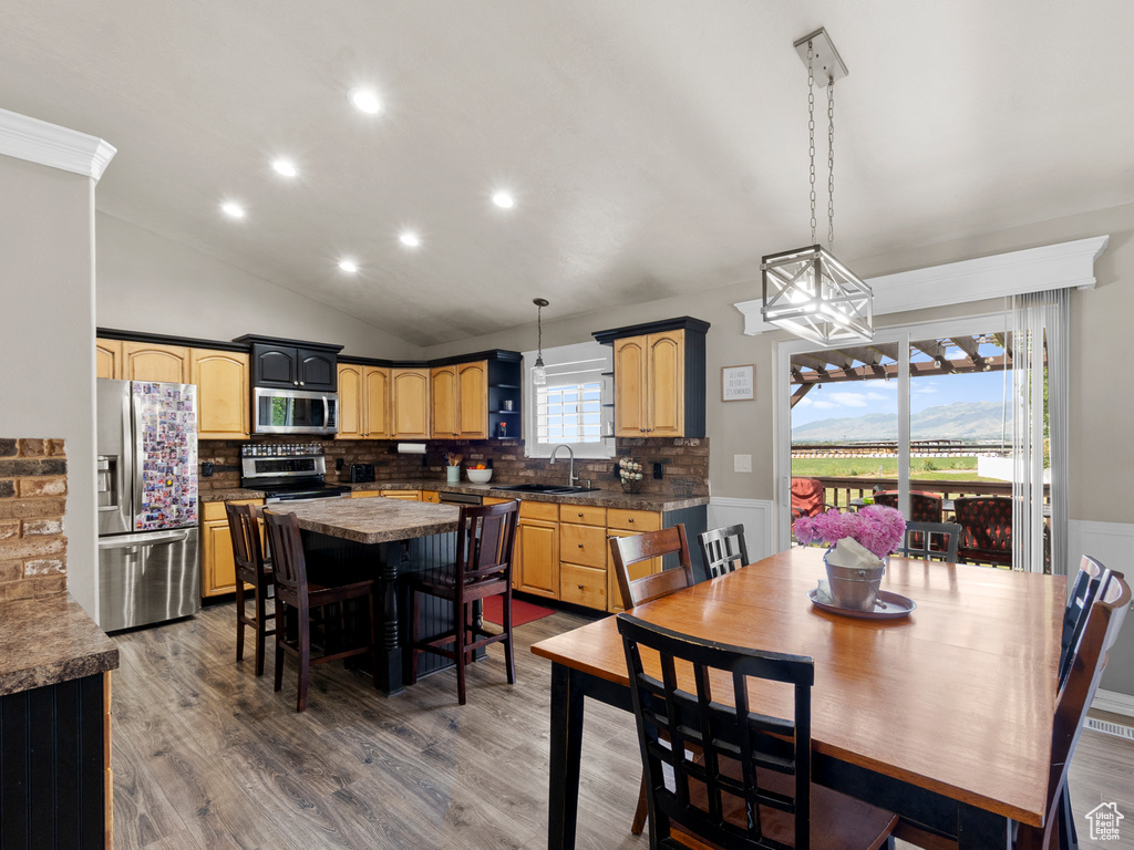 Dining space featuring wood finished floors, recessed lighting, lofted ceiling, and a chandelier