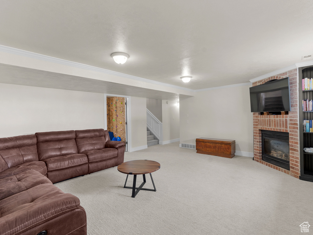 Carpeted living room with ornamental molding, stairway, a fireplace, and baseboards