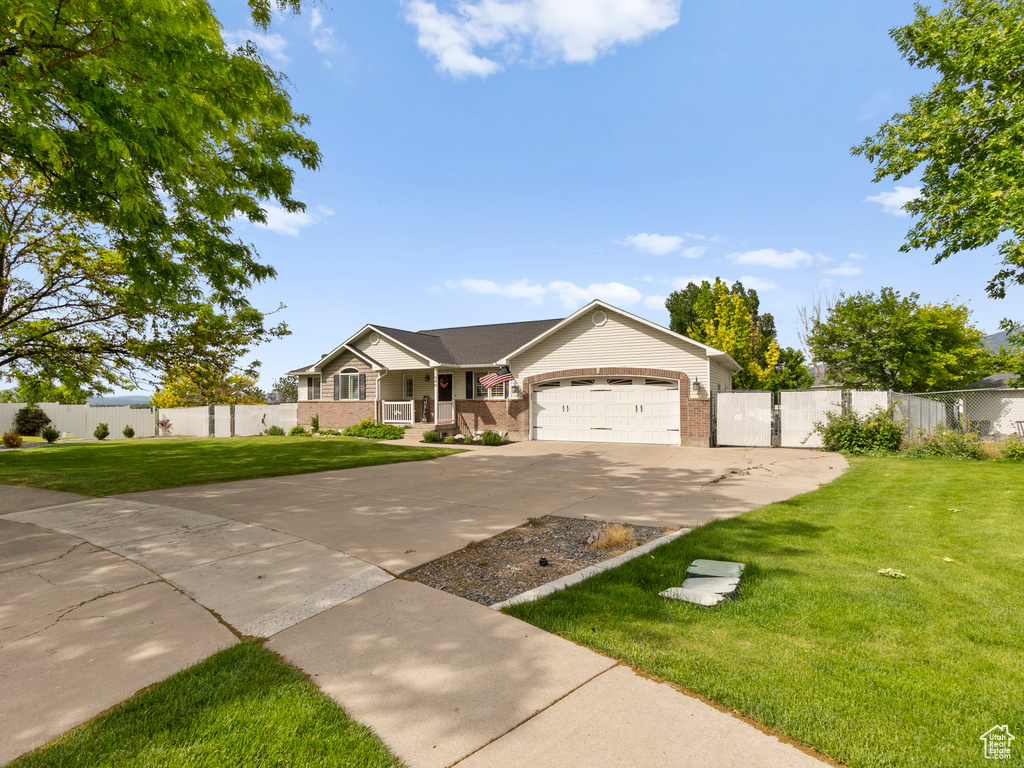 Ranch-style home featuring brick siding, a porch, driveway, and a garage