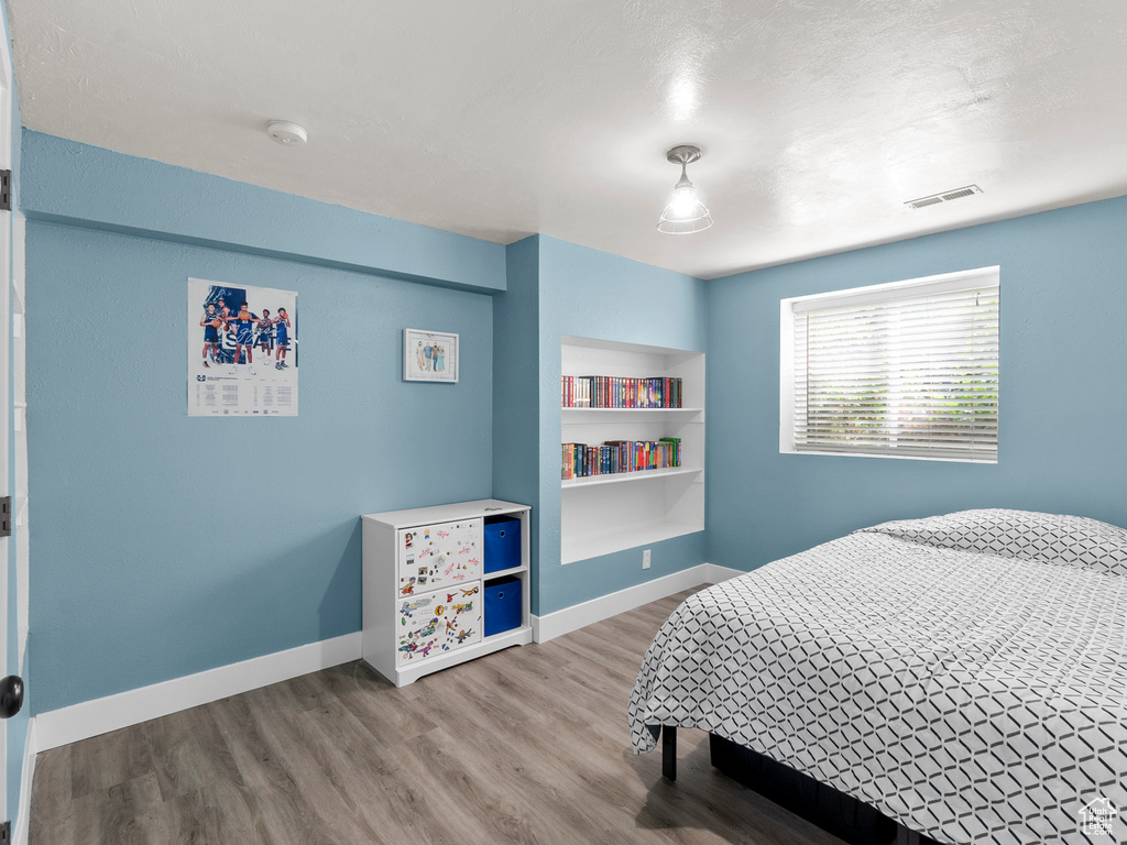 Bedroom with wood finished floors and baseboards