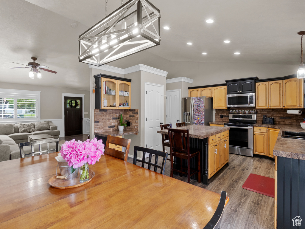 Dining room with ceiling fan, wood finished floors, vaulted ceiling, and recessed lighting