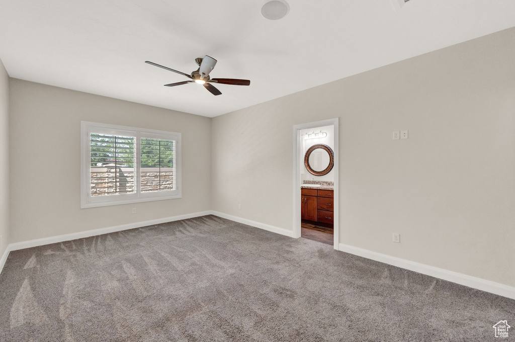 Empty room with carpet flooring, ceiling fan, and baseboards