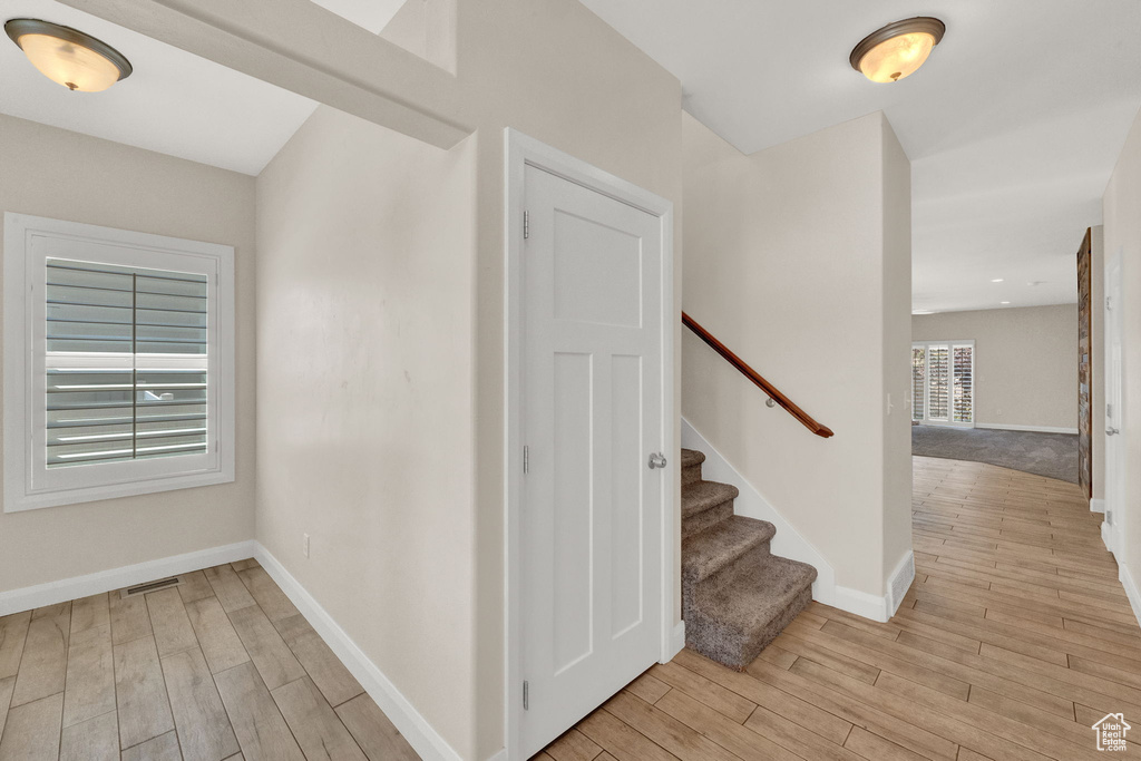 Stairs with wood finished floors and baseboards