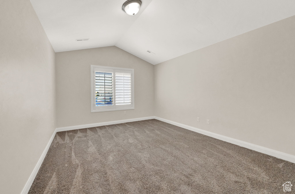 Bonus room featuring vaulted ceiling, carpet, and baseboards