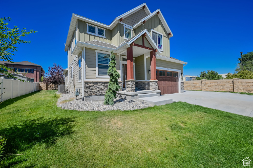Craftsman-style house with board and batten siding, concrete driveway, stone siding, an attached garage, and central AC unit