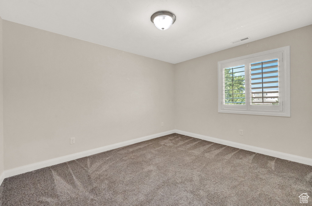 Empty room with carpet and baseboards