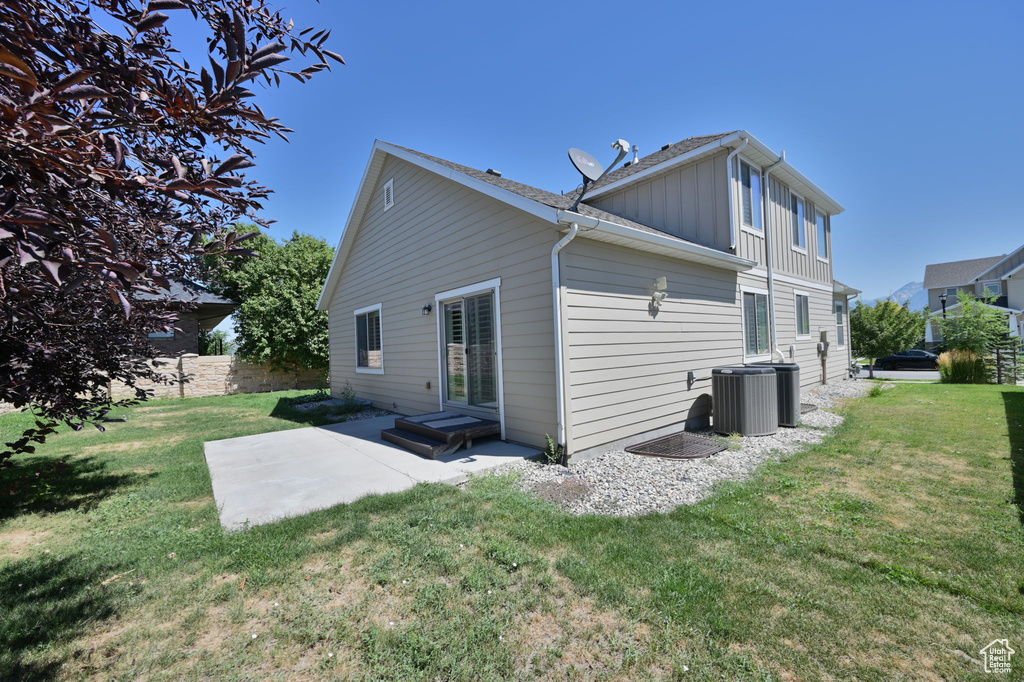 Rear view of house featuring board and batten siding, a patio, and cooling unit